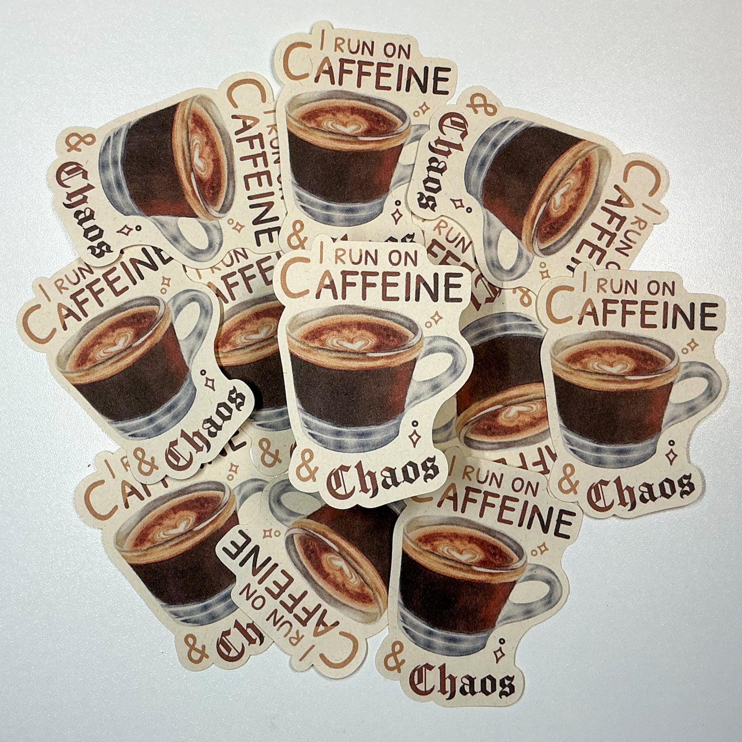 I Run On Caffeine & Chaos Die-Cut Sticker. This handmade coffee sticker features a hand drawn watercolor espresso shot with the words 'I run on caffeine & chaos'. Approximate size (WxH): 3 x 2.4 in. 100% Compostable, Biodegradable, and Recyclable. Printed with water-based ink on Compostable Natural Sugarcane Sticker Paper. Suitable for Home Compost Systems. NOT water resistant or waterproof.