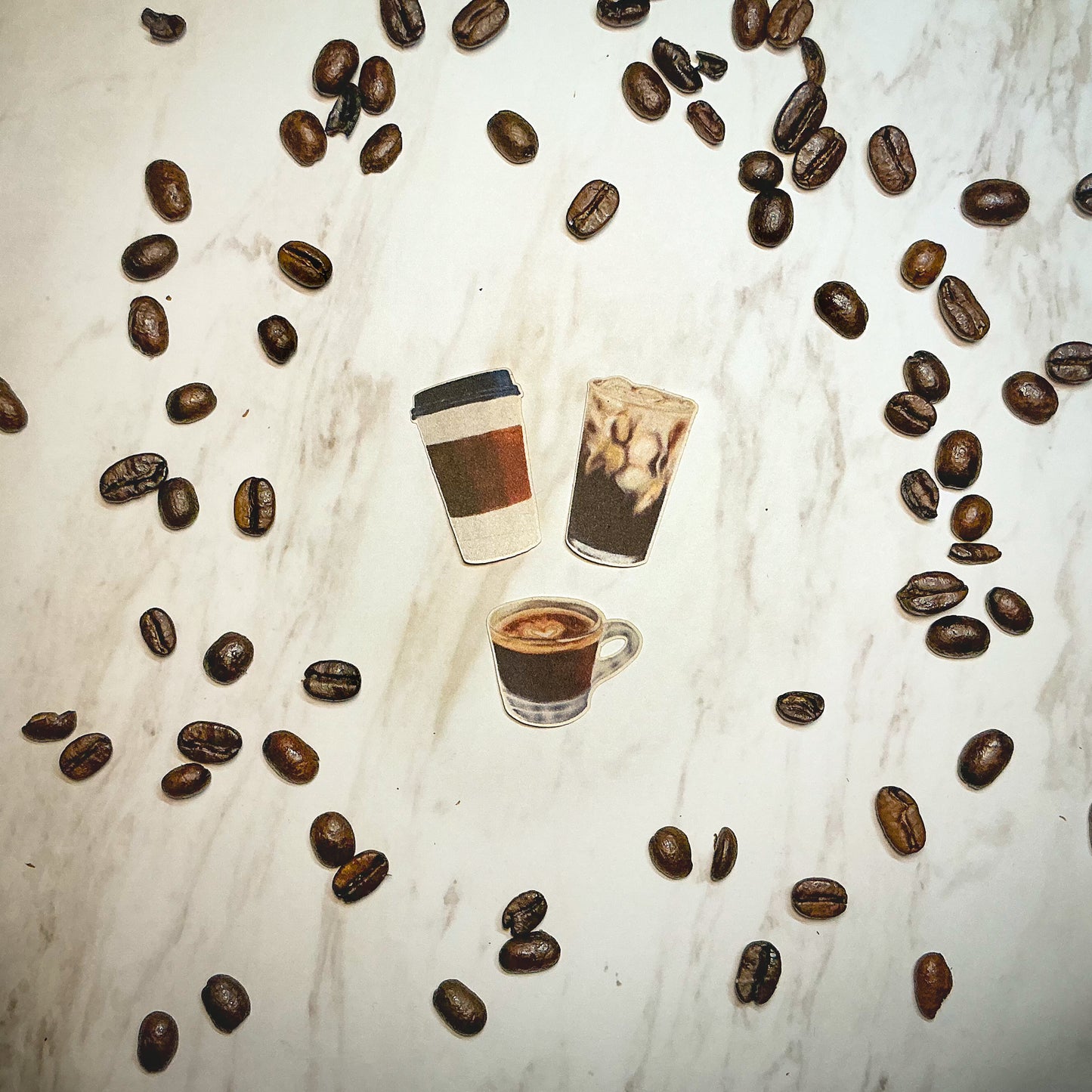 3 Mini Coffee Stickers featuring hand drawn Espresso, Iced Coffee, and a To-Go Cup surrounded by coffee beans