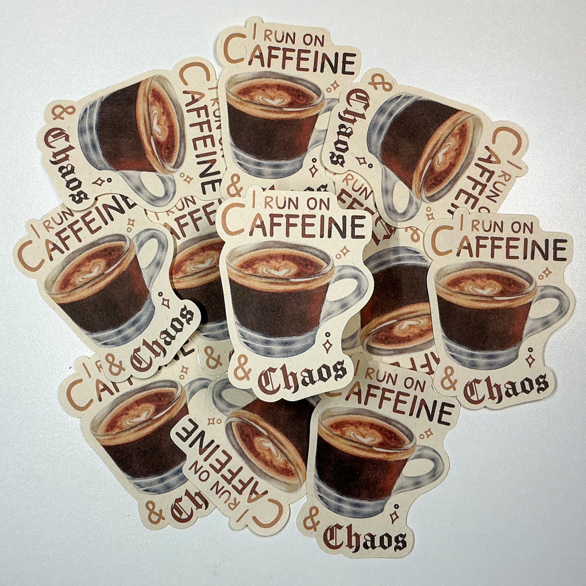 I Run On Caffeine & Chaos Die-Cut Sticker. This handmade coffee sticker features a hand drawn watercolor espresso shot with the words 'I run on caffeine & chaos'. Approximate size (WxH): 3 x 2.4 in. 100% Compostable, Biodegradable, and Recyclable. Printed with water-based ink on Compostable Natural Sugarcane Sticker Paper. Suitable for Home Compost Systems. NOT water resistant or waterproof.